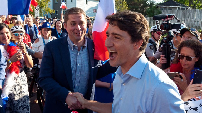 Prime Minister Justin Trudeau shakes hands with Conservative Leader Andrew Scheer during National Acadian Day celebrations