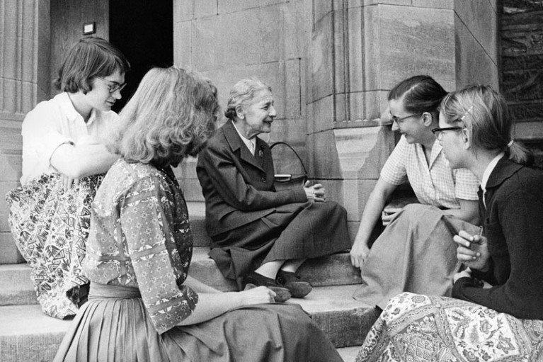 Lise Meitner sitting with a group of female students