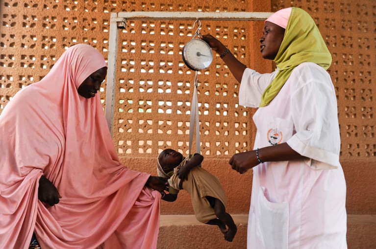 A baby is weighed as part of a nutrition project in Zinder, Niger.