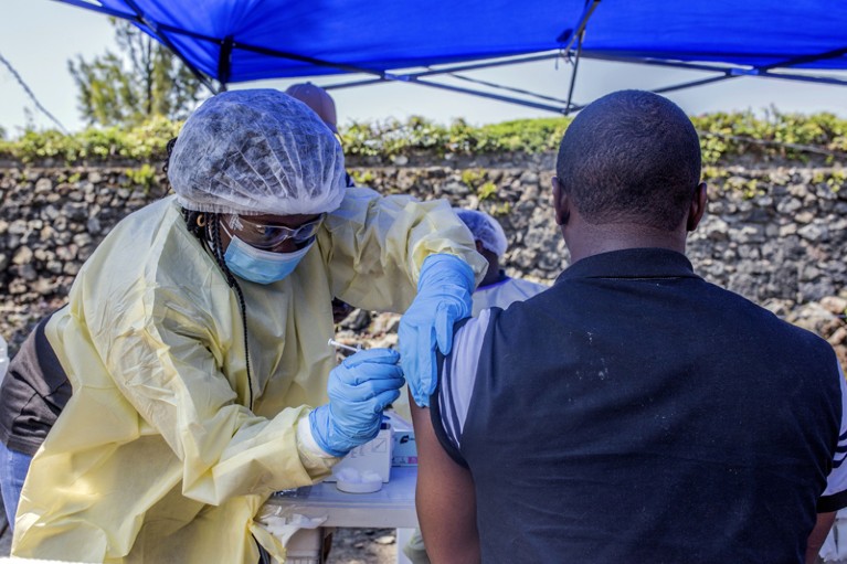 A man receives a vaccine against Ebola from a nurse