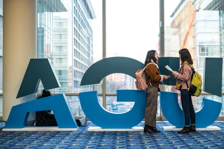 Women stand by and AGU sign at the AGU’s 2018 Fall Meeting