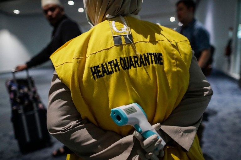 An Indonesian health quarantine official holds a thermal scanner, Soekarno-Hatta International Airport, Indonesia
