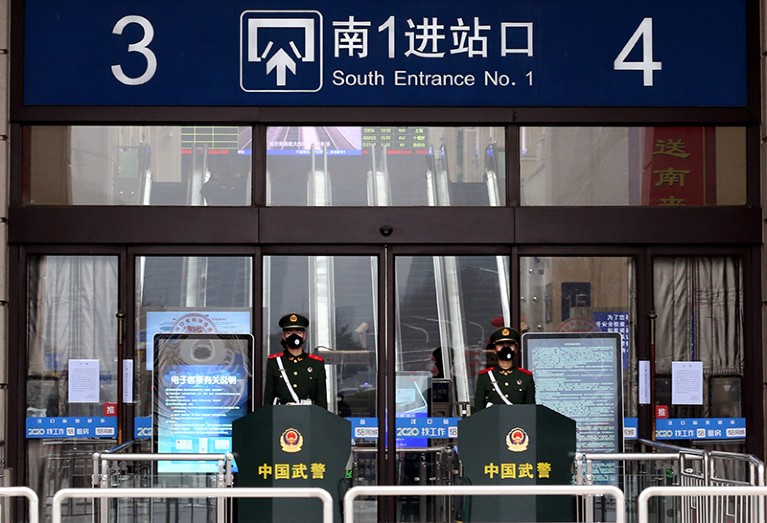 Chinese paramilitary officers wearing masks stand guard at an entrance of the closed Hankou Railway Station in Wuhan.