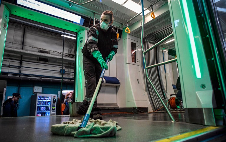 An employee wearing a face mask disinfects a metro train in Moscow