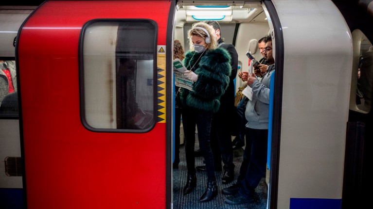 A commuter wears a mask as a precaution whilst travelling on a London Underground.