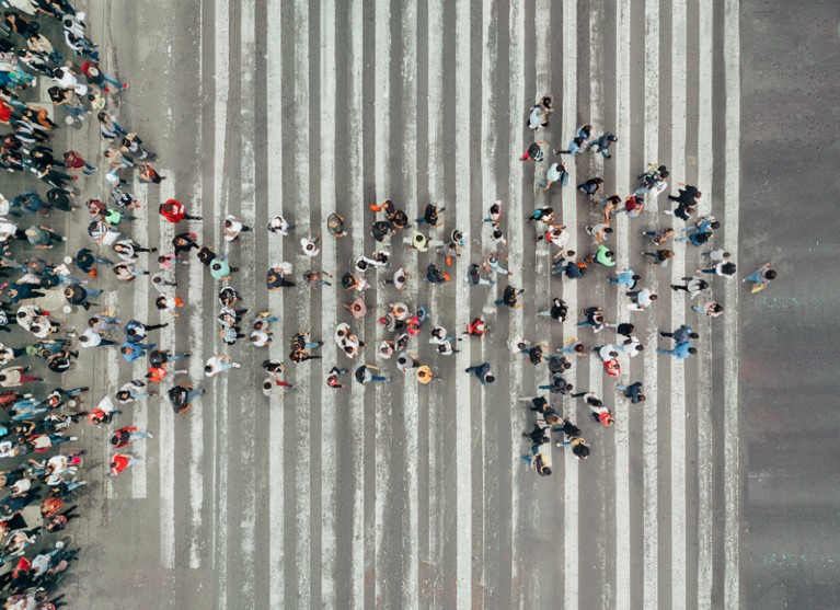 Overhead view of a crowd of people forming the shape of an arrow