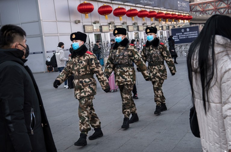 Chinese police officers wearing protective masks on patrol at a Beijing railway station.