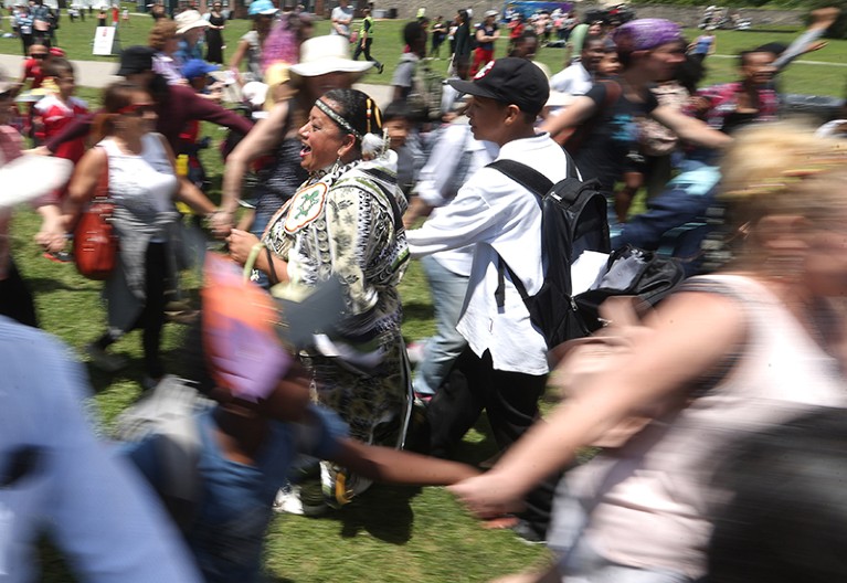Hundreds of people in a massive circle dance at an indigenous arts festival in Toronto.