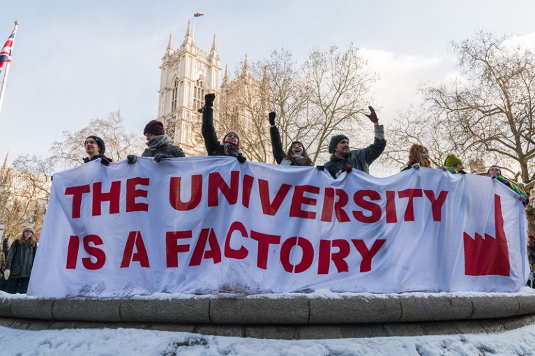 People holding a banner that reads: 'The university is a factory' in the UCU pensions strike, London