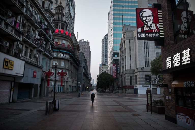 A resident wearing a protective mask walks on an empty business street in Wuhan, China