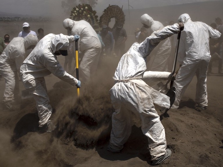 Chalco cemetery workers use protective equipment for COVID-19 to bury the deceased on June 7, 2020 in Mexico City.
