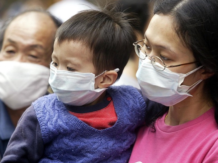 A grandfather, mother and her son wear masks on the street to protect against a deadly pneumonia virus in Hong Kong.