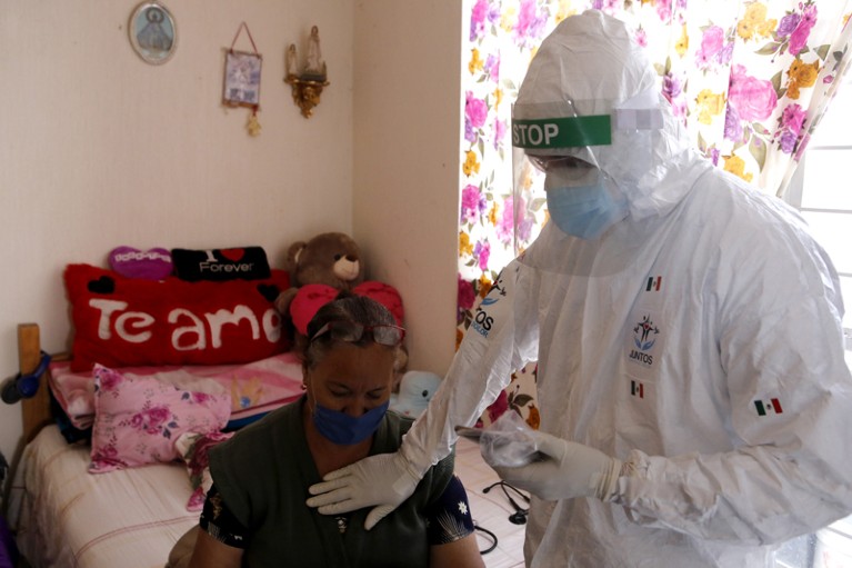 A volunteer doctor checks a woman infected with Covid-19 at home