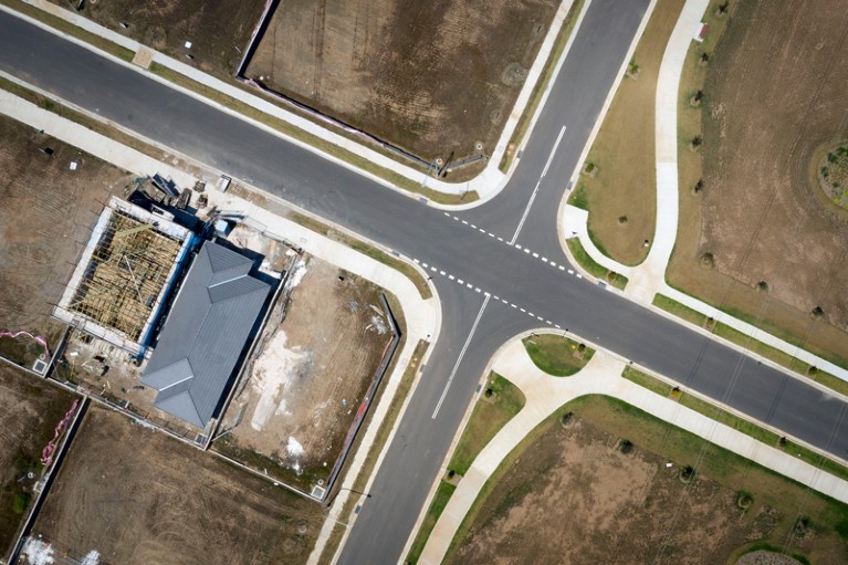 A birds-eye view of a construction site next to a road junction.