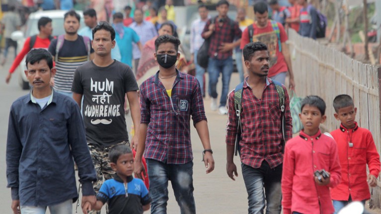 People wear protective mask to fight against the Coronavirus as they moves in the market area in an eastern Indian state.