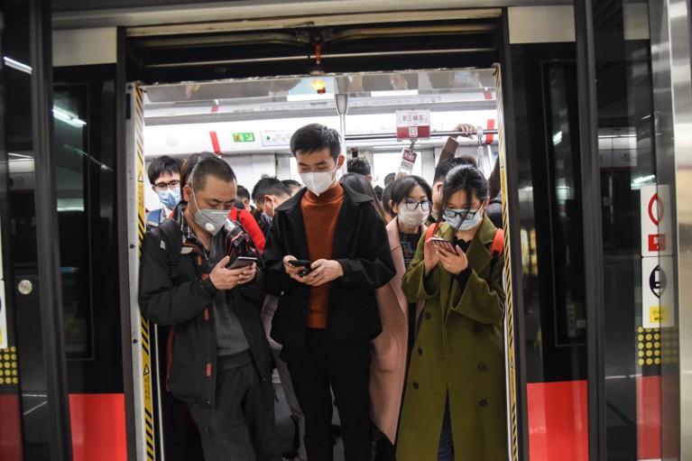 Masked commuters on a subway train, China