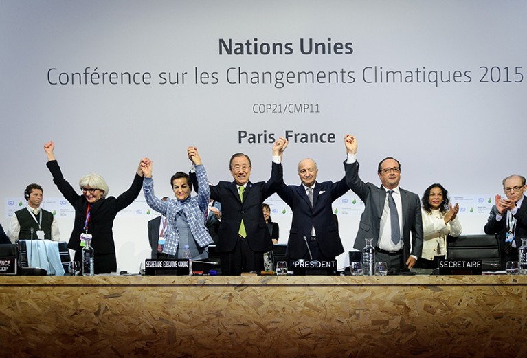 The conference leaders raise hands together after adopting a global warming pact at the COP21 Climate Conference in 2015.