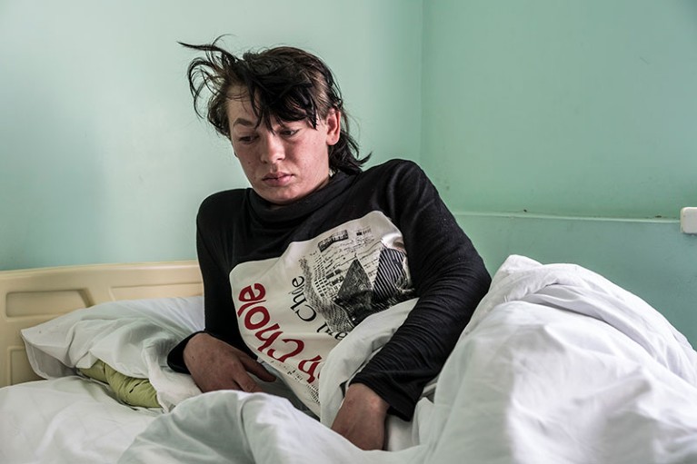 A woman rests in bed at a medical centre while being treated for measles in Kiev.