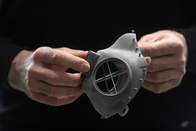 Closeup of a man's hands holding a respirator made with 3D technology