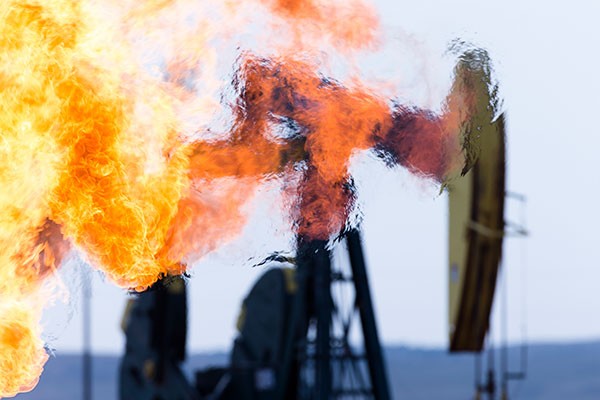 Methane gas flare and pump jack at an oil well in North Dakota