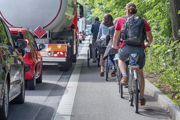 Heavy traffic on a road with a busy cycle lane alongside