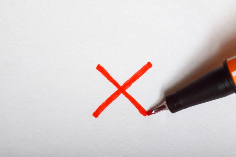 An 'X', signifying rejection, written on a sheet of paper with a red pen.