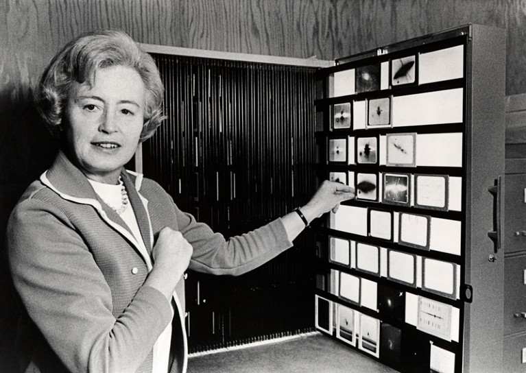 Margaret Burbidge posing for a photograph in front of a display of astronomical glass plates