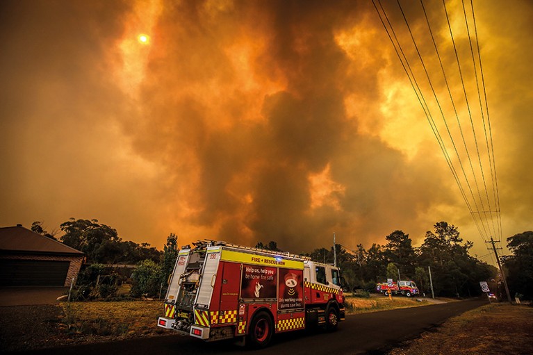A fire engine sits on street where the sky is filled with smoke