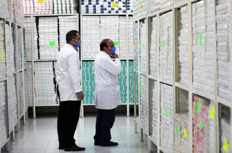 Employees of a Syrian pharmaceutical factory check shelves packed with medicines