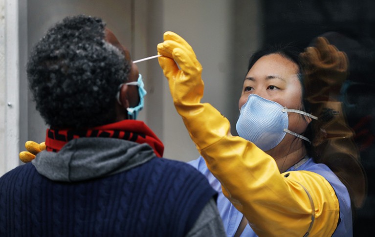 A nurse practitioner takes swab samples from a person in Los Angeles, California