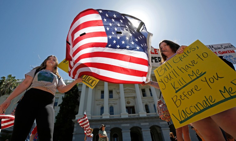 Two sisters holding the US flag and protest boards