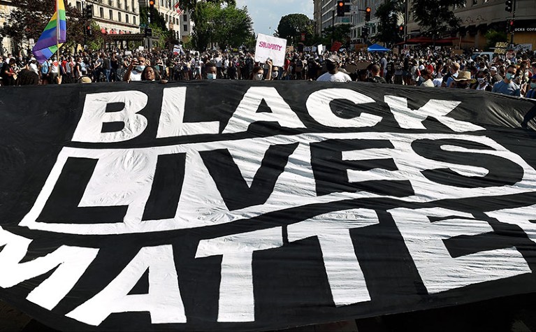 Demonstrators deploy a " Black Lives Matter" banner near the White House during a demonstration against racism