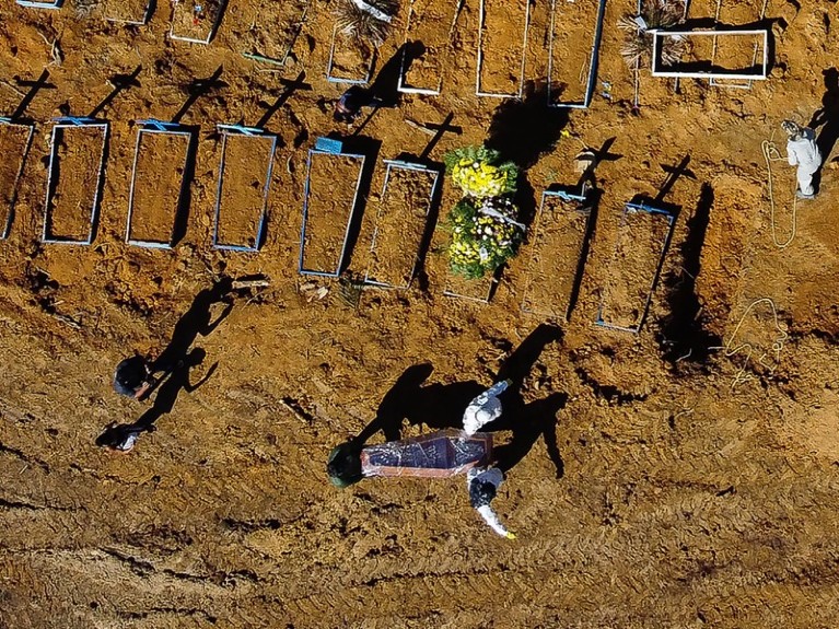 Aerial view showing a coffin being taken to its grave at the Nossa Senhora Aparecida cemetery, Brazil.