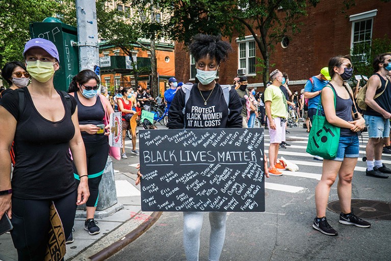 A woman holds up a sign of the victims during a Black Lives Matter protest in New York City