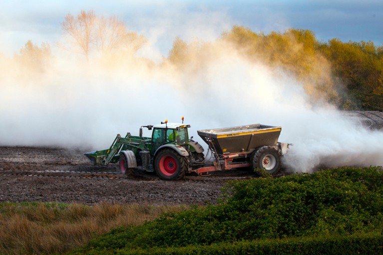 Farmer lime spreading with a tractor