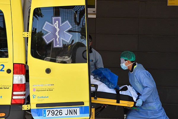 A healthcare worker carries a patient out of an ambulance outside the Arnau de Vilanova University Hospital in Lleida
