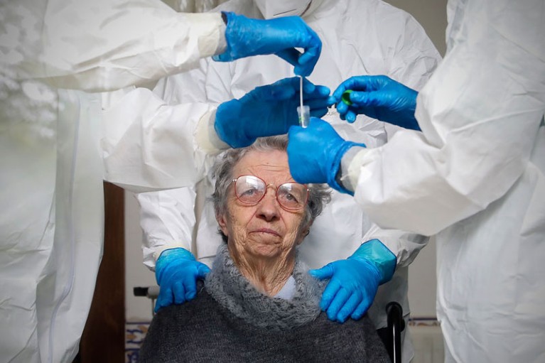 An elderly woman undergoes COVID-19 screening tests