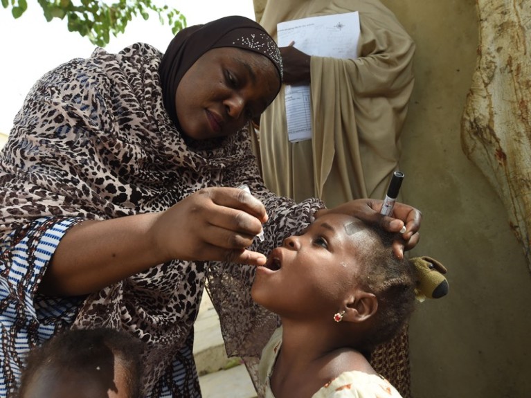 NICEF health consultant Hadiza Waya tries to immunise a child during vaccination campaign against polio, Nigeria.