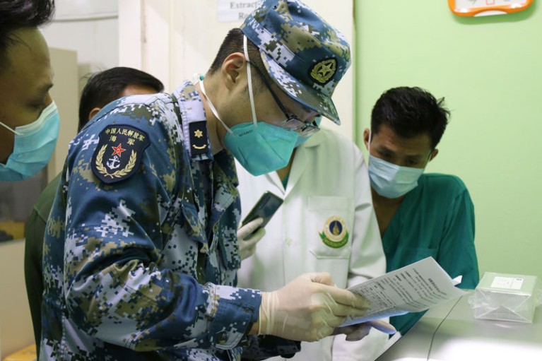 A member of a Chinese military medical team works at a laboratory for testing COVID-19