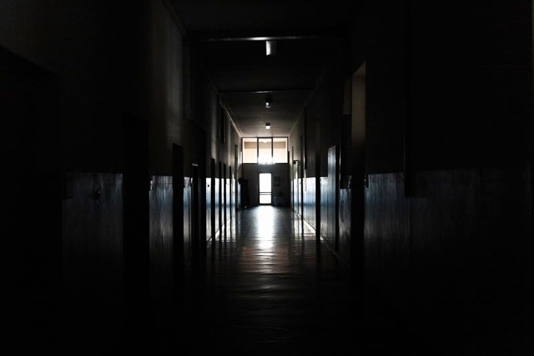Light shining from a door in a dark hallway