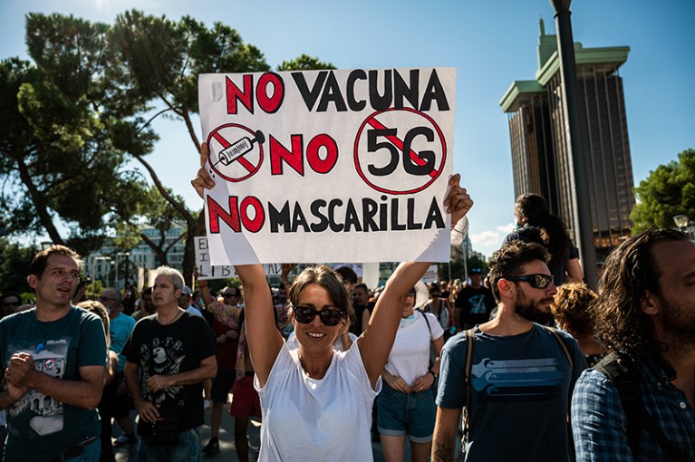 A protestor holds a sign against the use of vaccine, 5G and mask wearing in Spain