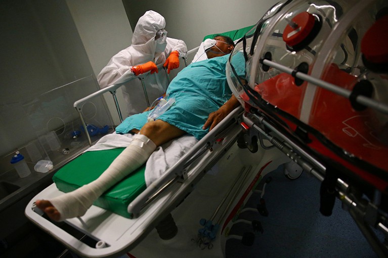 A patient suffering from the COVID-19 rests on his bed as paramedics transfer him between hospitals in Mexico City