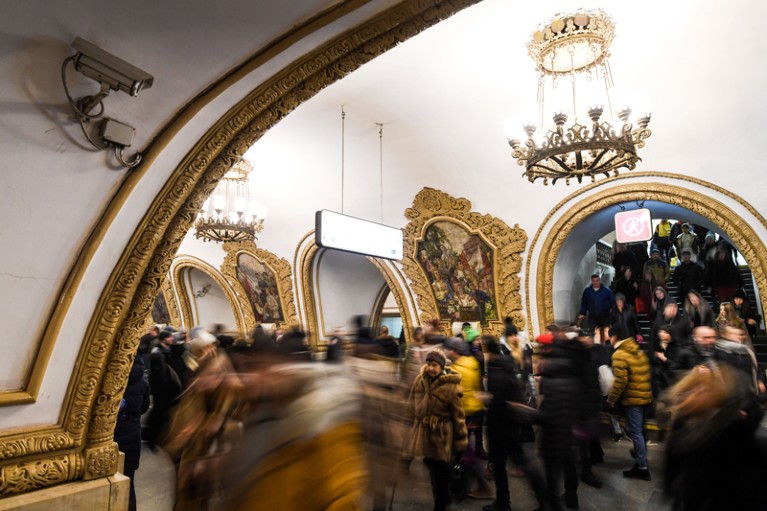 A surveillance camera records crowds passing through an ornately designed metro station in Moscow