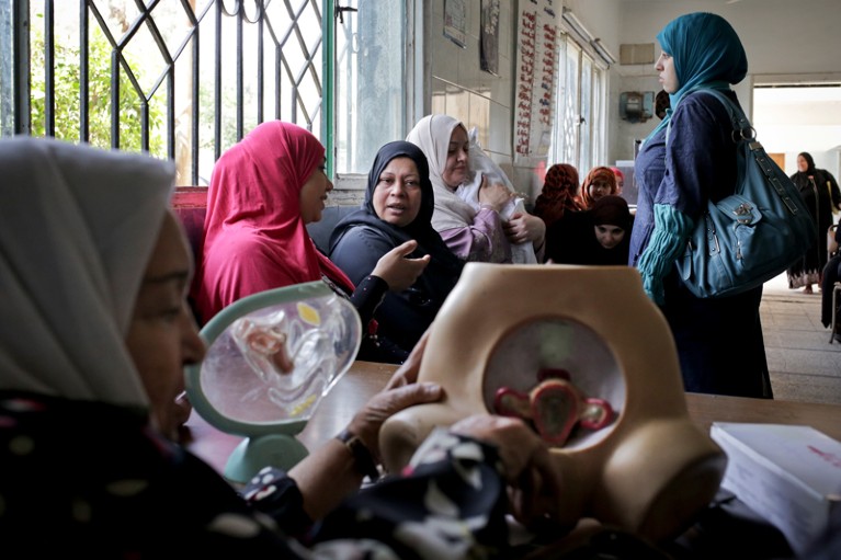 A volunteer health worker uses medical models to explain contraceptive options at a women’s clinic in Cairo