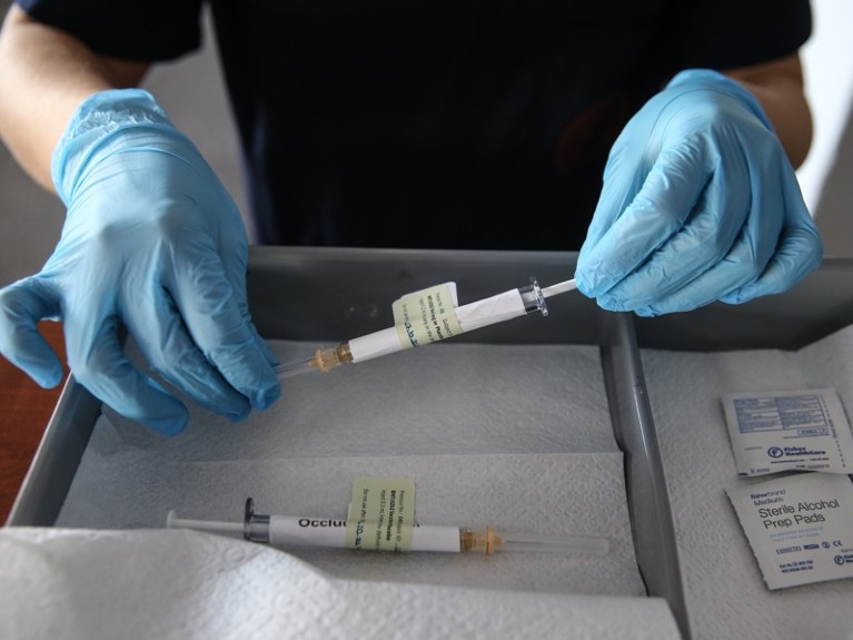 A health care worker holds an injection syringe of the phase 3 vaccine trial, developed against the novel coronavirus.