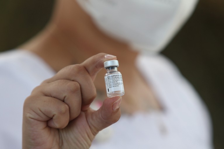 A nurse holds a vial of the Pfizer vaccine
