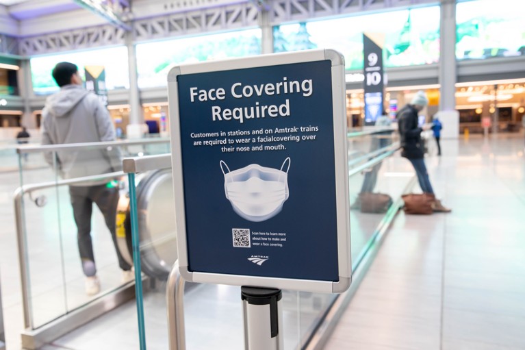 A sign advertising a face mask requirement is displayed at the Moynihan Train Hall in New York