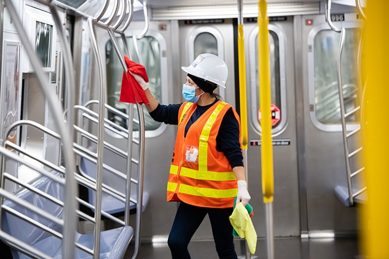 An MTA cleaning contractor cleans and disinfects a New York City subway car