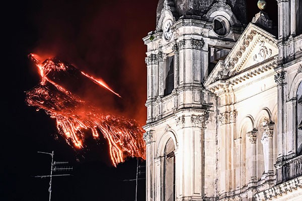 East crater of the Etna Volcano erupting with high lava fountains behind the Mother Church of Belpasso in Catania, Italy.