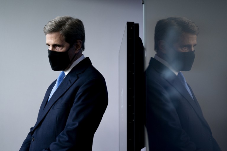 John Kerry wearing a protective mask during a news conference